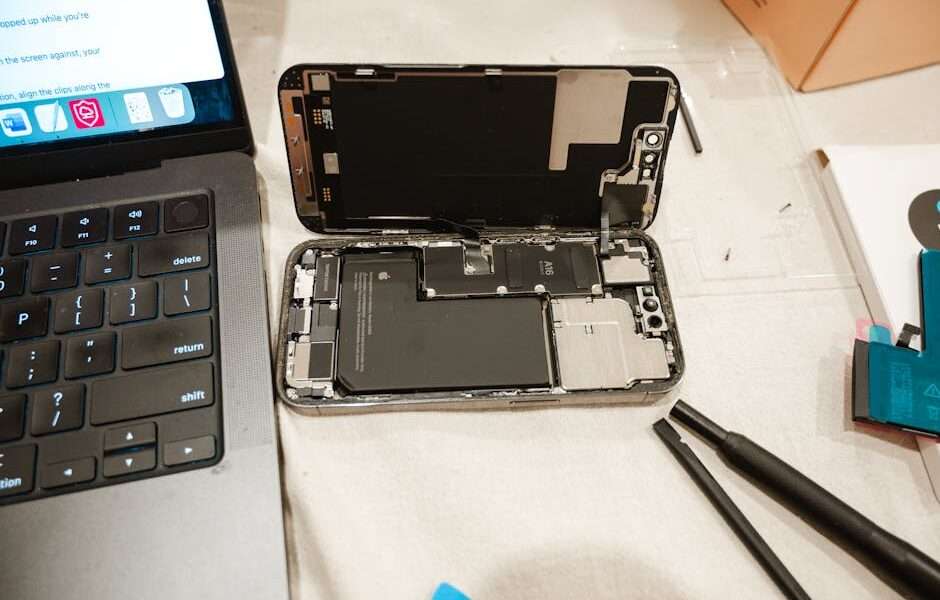 otwarty smartfon leżący koło laptopa
